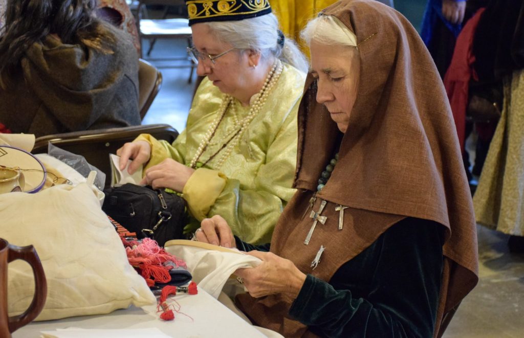 Two people hand-sewing