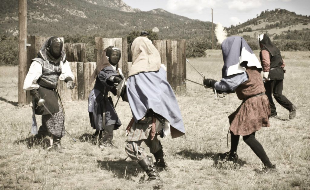 Five people fencing in front of a wood fort. Photo by Bree Pye.