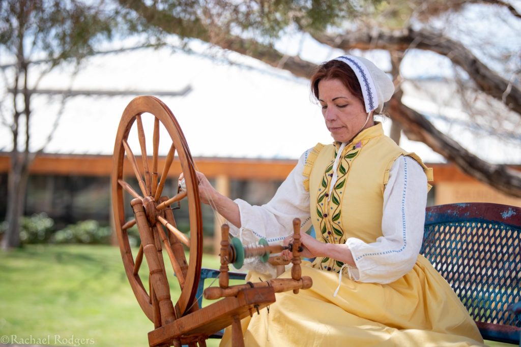 A woman working a spinning wheel