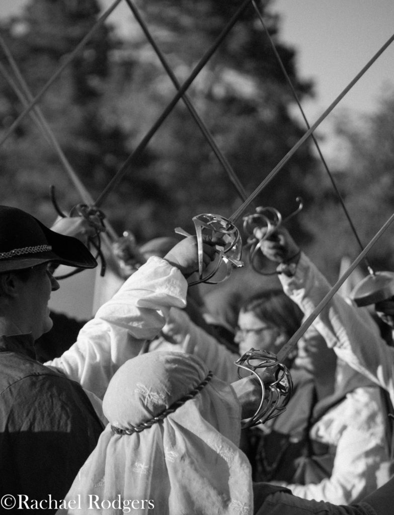 People making a tunnel by holding up fencing swords